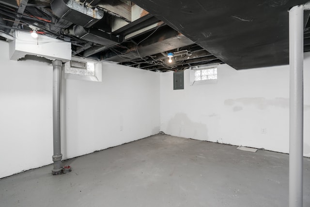 basement with electric panel and a wealth of natural light