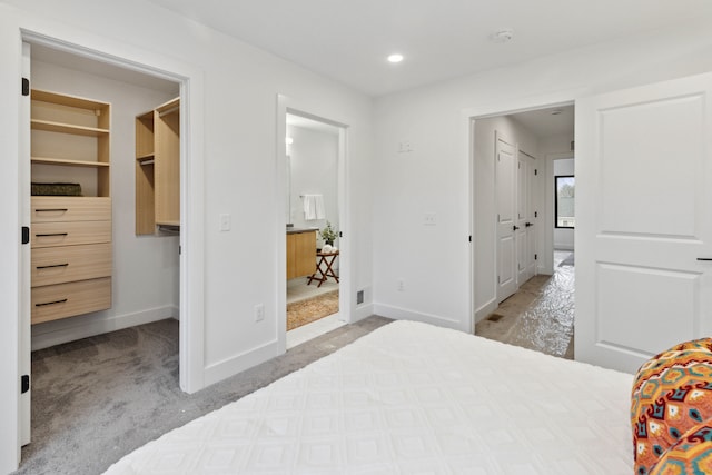 bedroom with a spacious closet, light carpet, and a closet