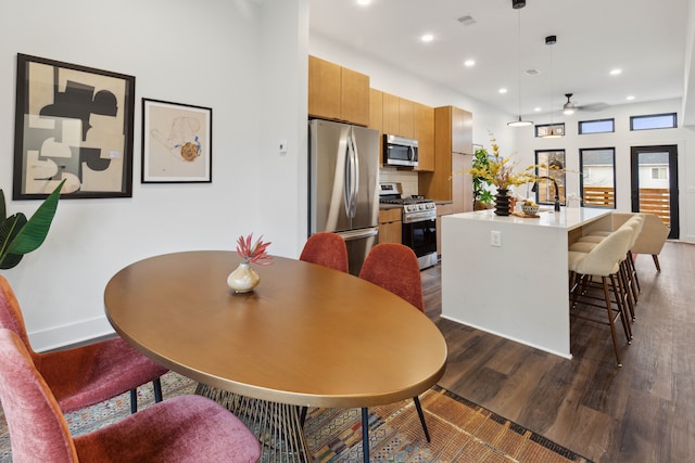 dining room featuring dark hardwood / wood-style floors, ceiling fan, and sink