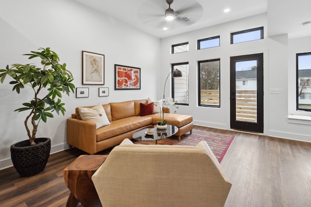 living room featuring ceiling fan and dark hardwood / wood-style flooring