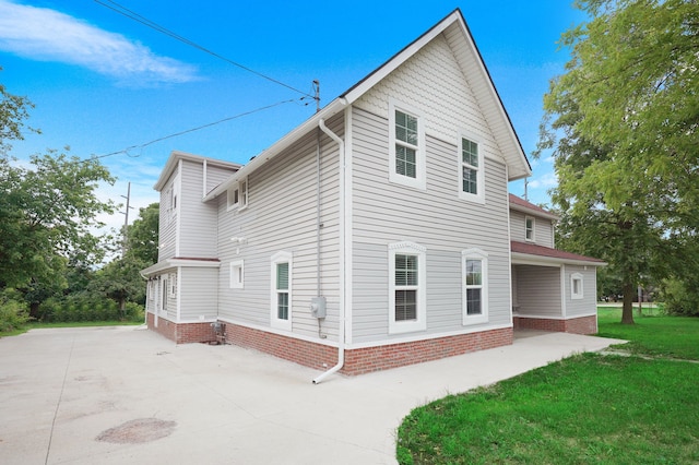 view of side of property with a yard and a patio area