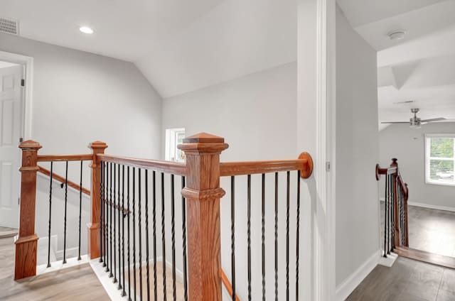 stairway featuring hardwood / wood-style floors, vaulted ceiling, and ceiling fan