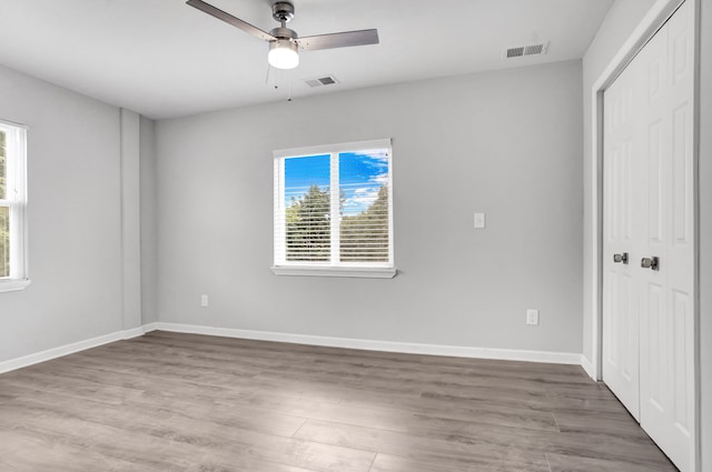 unfurnished bedroom with light wood-type flooring, a closet, and ceiling fan