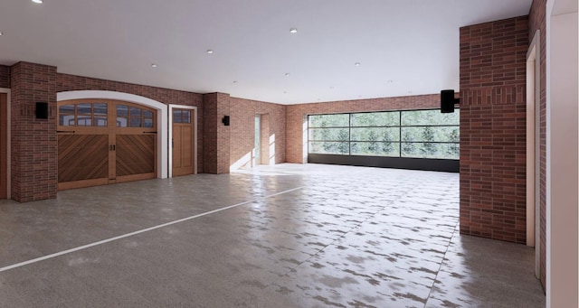 interior space featuring brick wall and concrete flooring