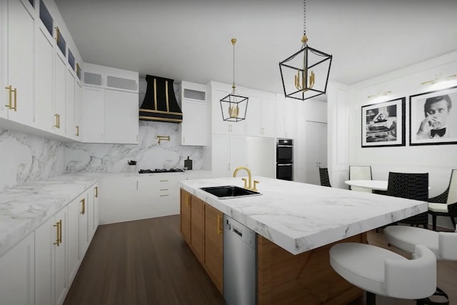 kitchen featuring a sink, tasteful backsplash, stainless steel dishwasher, and a kitchen island with sink