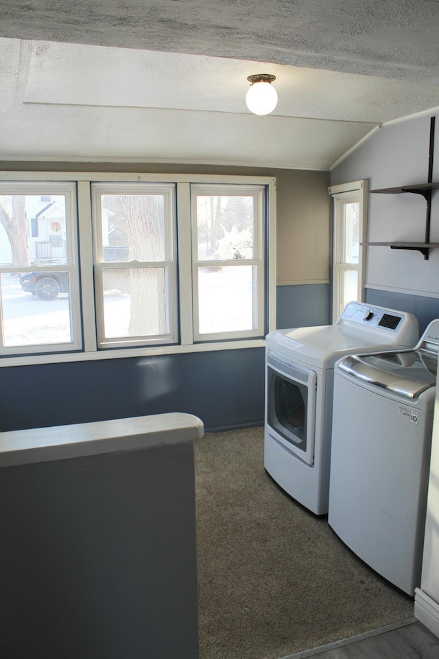 laundry room featuring a textured ceiling, separate washer and dryer, and dark carpet