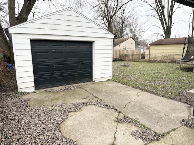 garage with a lawn and a trampoline