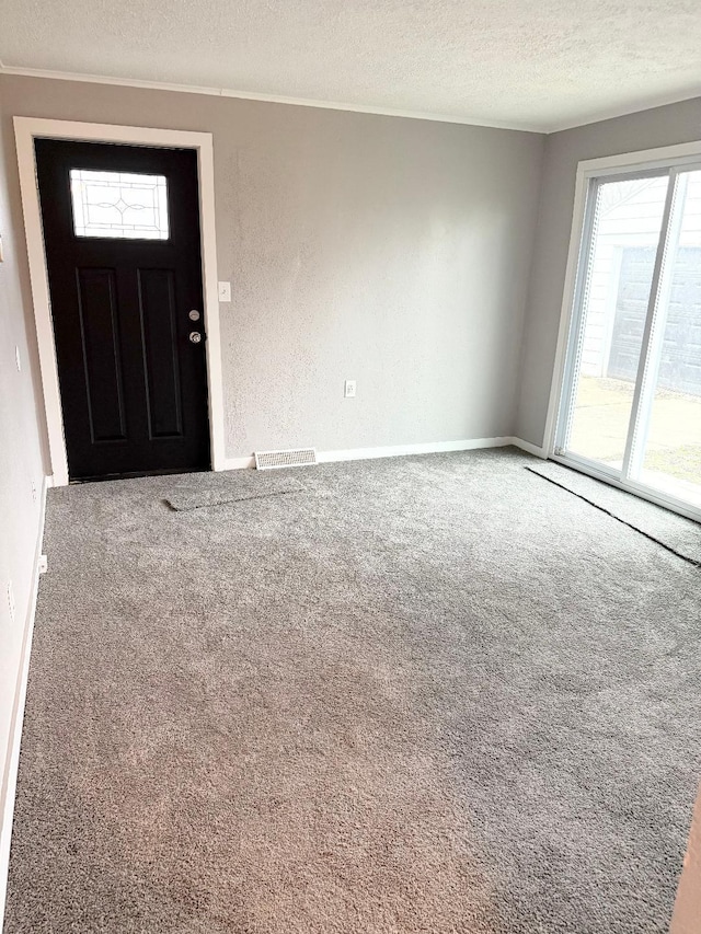 entryway with a textured ceiling and carpet floors