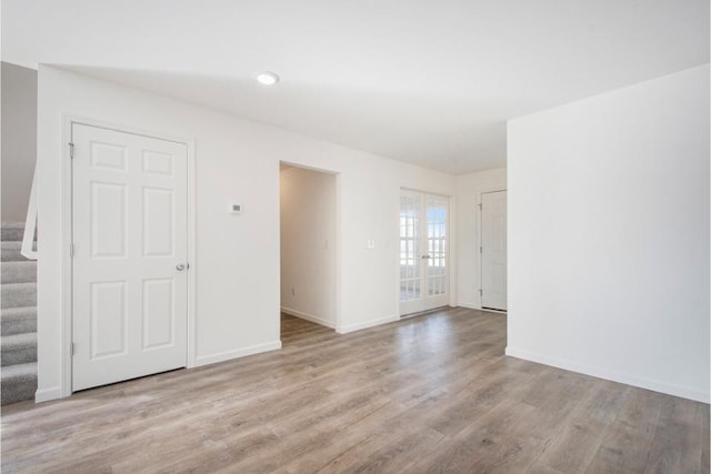 empty room featuring french doors and light wood-type flooring