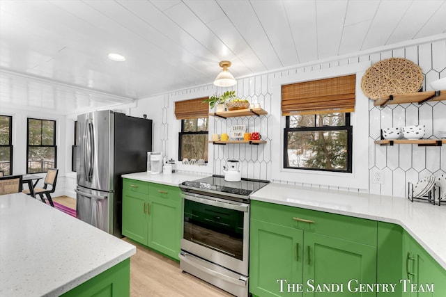 kitchen featuring stainless steel appliances, green cabinetry, light wood-type flooring, and decorative backsplash