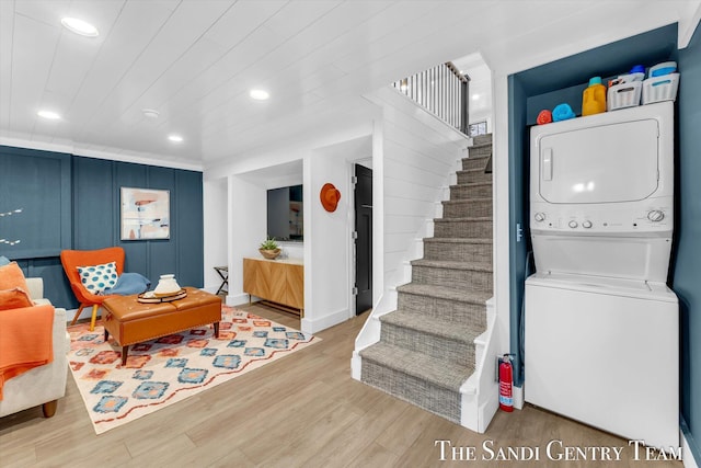 interior space featuring stacked washer and dryer, light hardwood / wood-style flooring, and wood ceiling