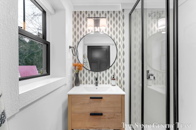 bathroom featuring a shower with door, a healthy amount of sunlight, and vanity