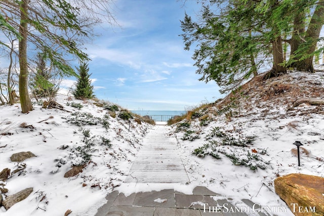 view of snow covered land with a water view