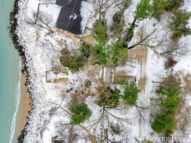 snowy aerial view featuring a view of the beach and a water view