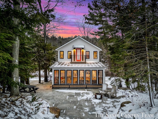 snow covered property with an outdoor fire pit and a patio area