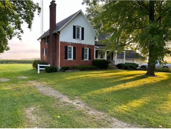 5721 N Rossman Rd W, Kingston, MI 48741 - view of front of home with a chimney, a front yard, and brick siding