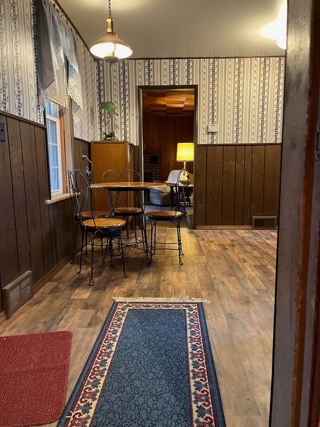 5721 N Rossman Rd W, Kingston, MI 48741 - dining space with wood finished floors, wallpapered walls, and wooden walls