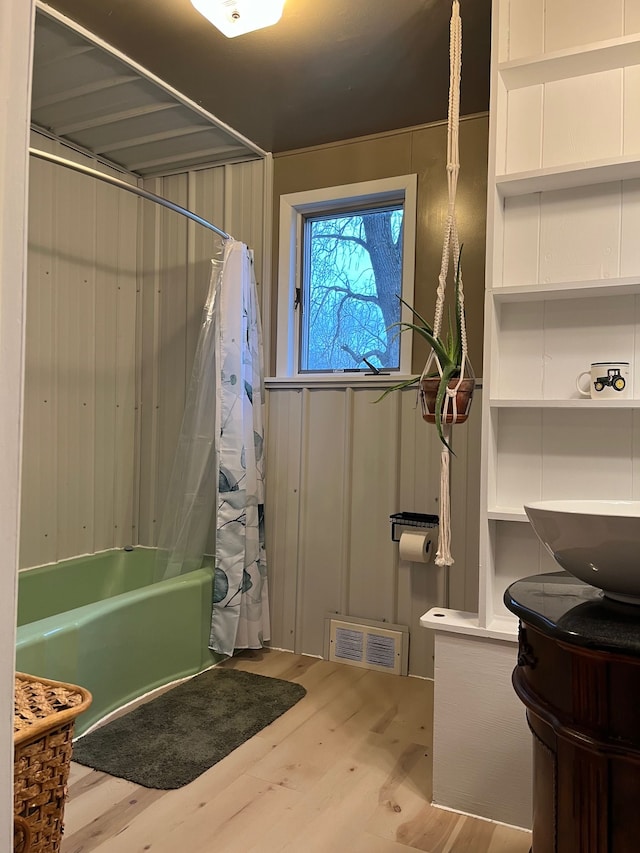 5721 N Rossman Rd W, Kingston, MI 48741 - full bath featuring shower / bath combination with curtain, wood finished floors, and vanity