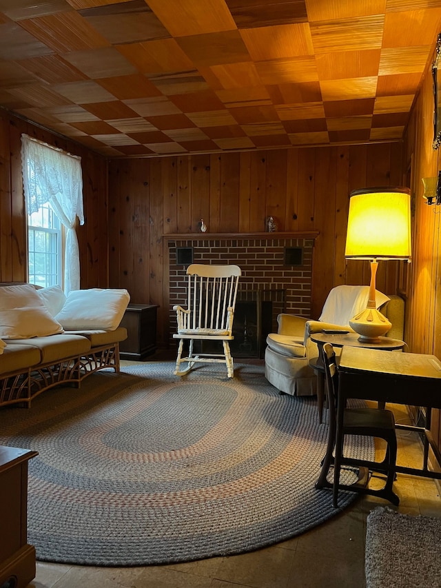 sitting room featuring a brick fireplace and wooden walls