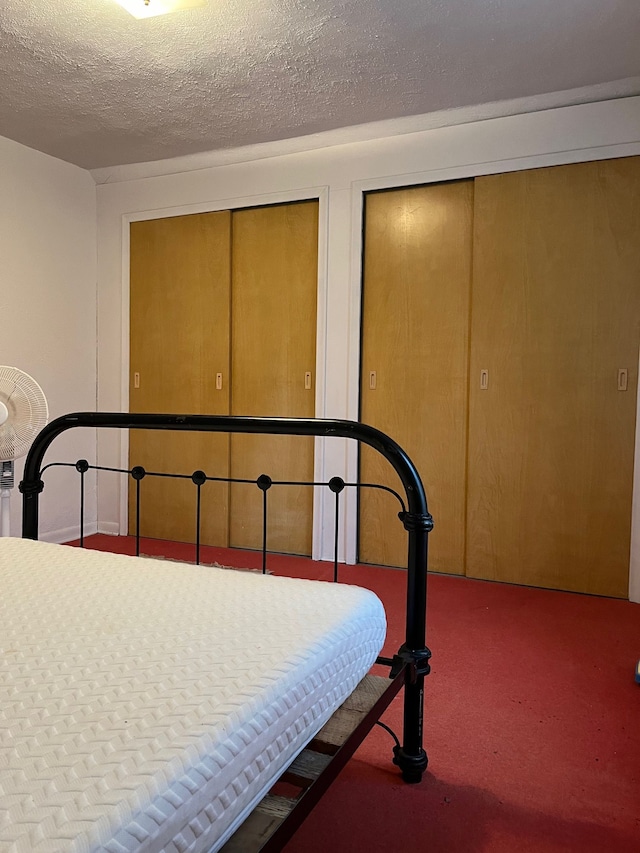 bedroom with a textured ceiling and carpet floors