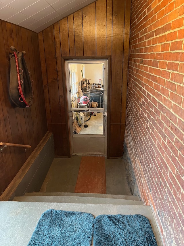 interior space featuring brick wall and wood walls