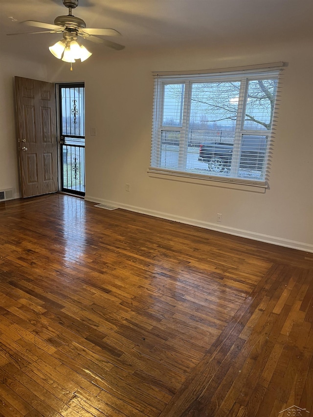 unfurnished room with ceiling fan and dark wood-type flooring