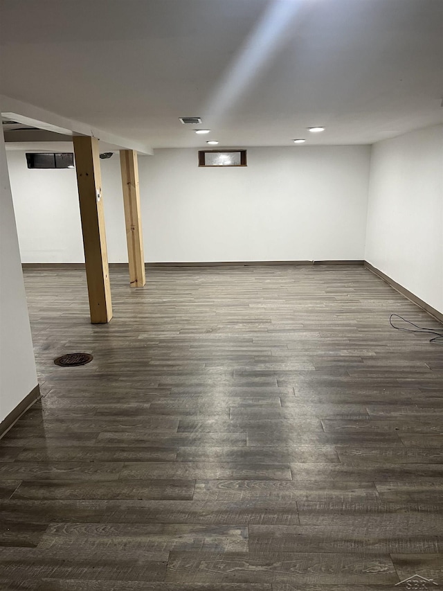 basement with dark hardwood / wood-style floors