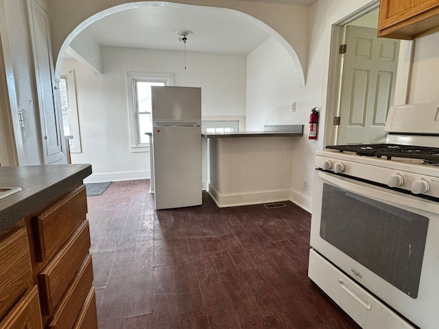 kitchen featuring dark hardwood / wood-style flooring and white appliances