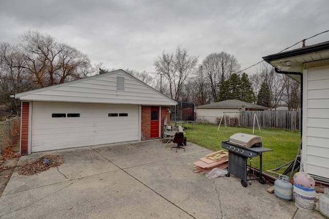 garage with a trampoline and a yard