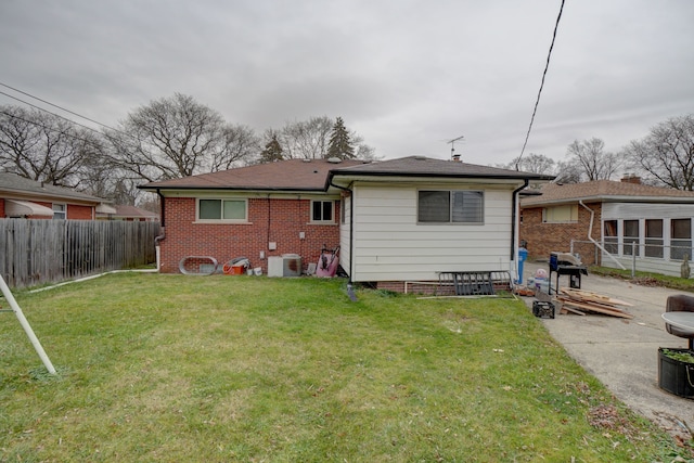 back of house with central AC unit and a lawn