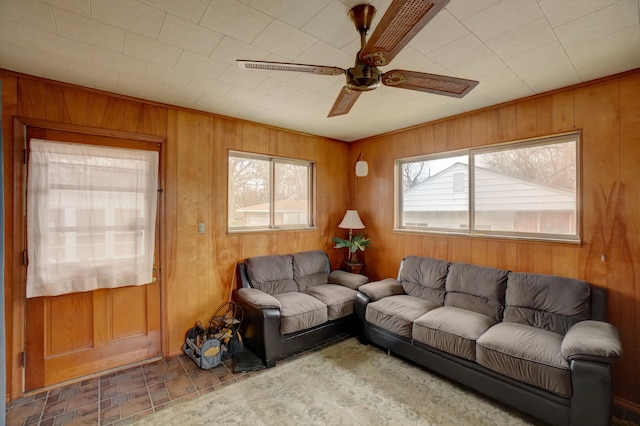 living room with ceiling fan and wooden walls