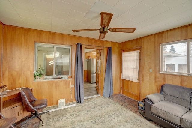 living room with wooden walls and ceiling fan