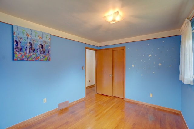 unfurnished bedroom featuring a closet and light hardwood / wood-style flooring