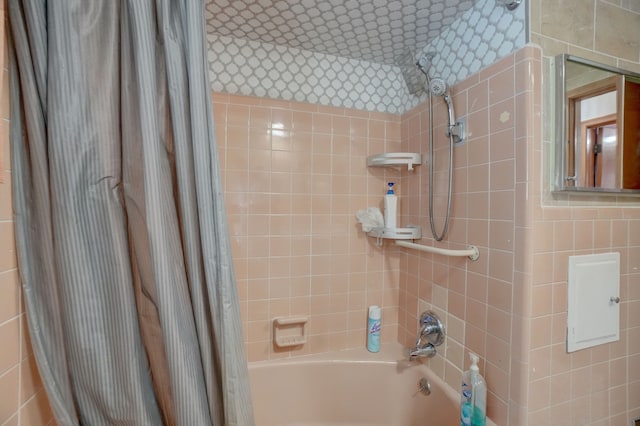 bathroom with tile walls and shower / tub combo