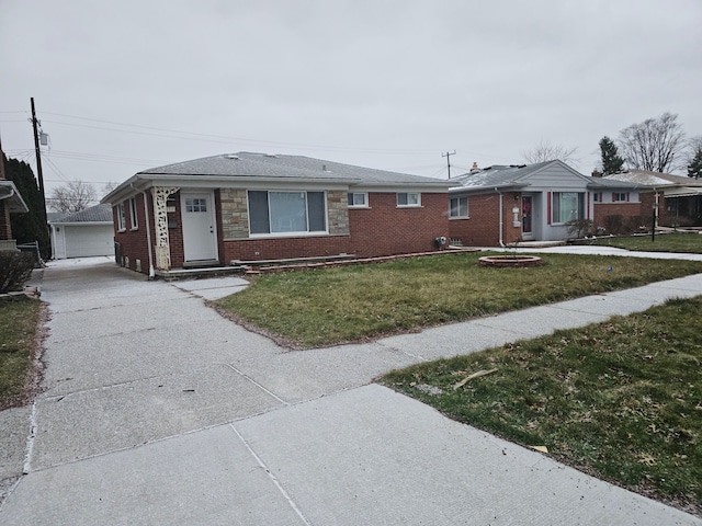 single story home featuring a garage, an outbuilding, and a front lawn