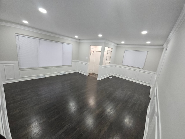 empty room with dark hardwood / wood-style flooring and crown molding