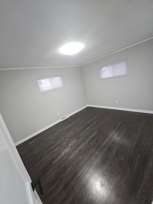 basement with dark hardwood / wood-style floors and crown molding