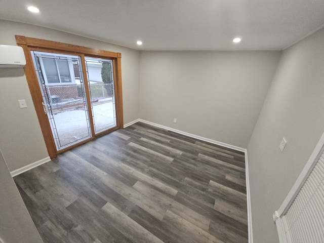 empty room featuring dark hardwood / wood-style floors and a wall unit AC