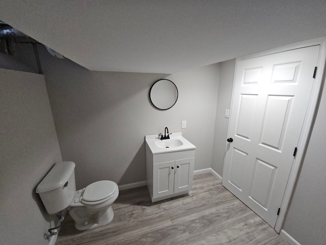 bathroom with wood-type flooring, vanity, and toilet