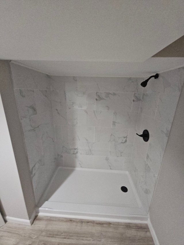 bathroom featuring wood-type flooring and tiled shower