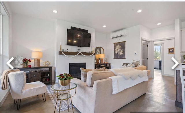 living room with a wall mounted air conditioner and concrete flooring