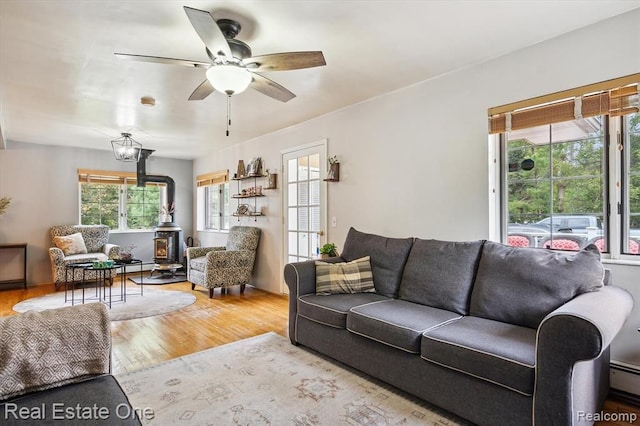 living room featuring hardwood / wood-style flooring, ceiling fan, and baseboard heating