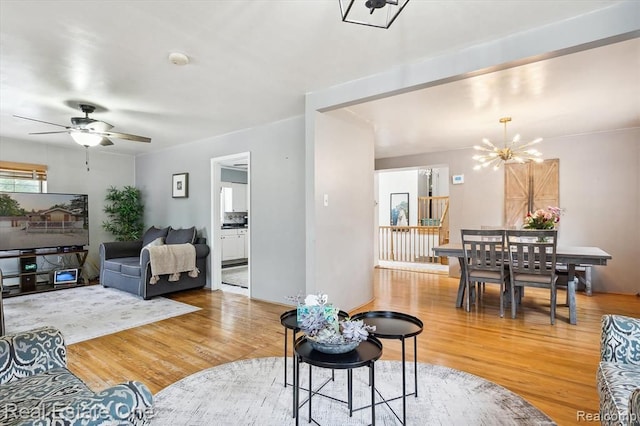 living room featuring hardwood / wood-style floors and ceiling fan with notable chandelier