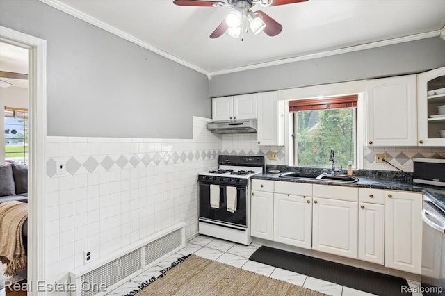 kitchen with white cabinets, appliances with stainless steel finishes, ornamental molding, and sink