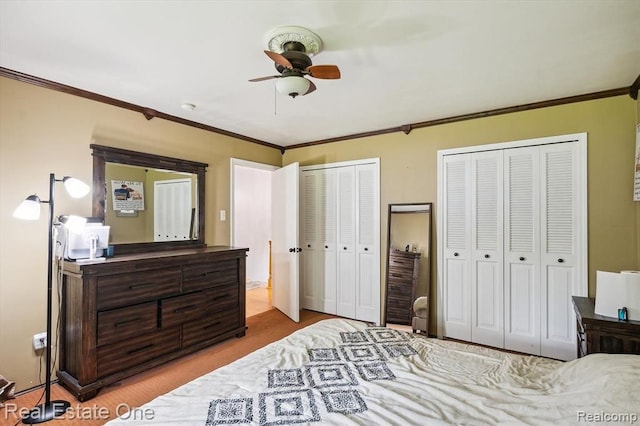 bedroom with two closets, ceiling fan, and crown molding