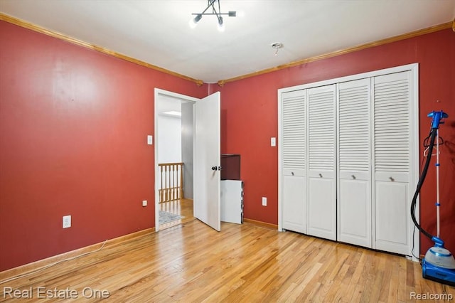 unfurnished bedroom featuring light hardwood / wood-style flooring, a closet, and ornamental molding