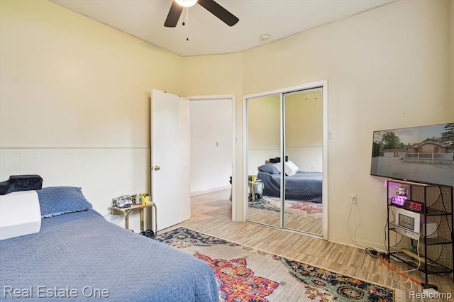 bedroom with wood-type flooring, a closet, and ceiling fan