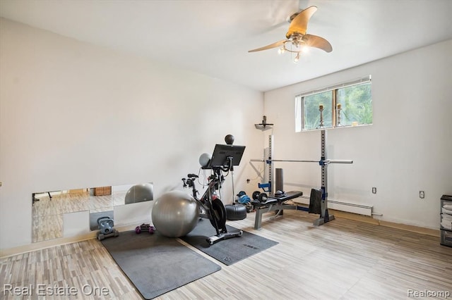 exercise area with ceiling fan and a baseboard heating unit