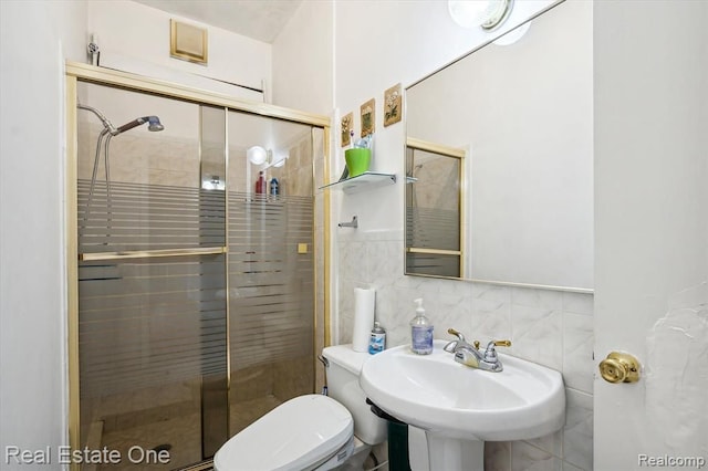 bathroom with tile walls, sink, an enclosed shower, and toilet