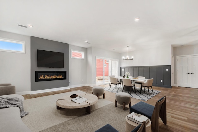 living room featuring an inviting chandelier and light hardwood / wood-style flooring